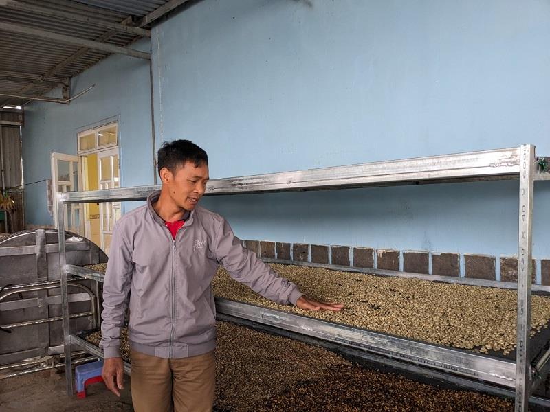 Anh Liêng Jrang Ha Hoang bên hệ thống phơi sấy cà phê của gia đình