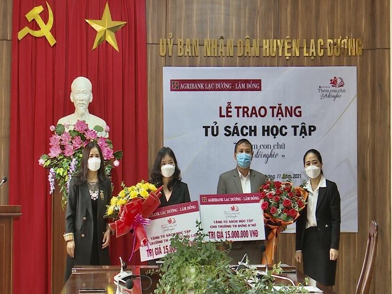 Bà Phan Thị Hà Lâm (phải ảnh) tặng sách cho trường Tiểu học Đưng K’Nớ và trường Tiểu học&THCS Long Lanh