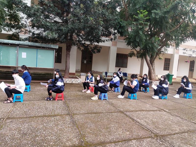 Học sinh trường THPT Lang Biang ngồi xếp hàng ngay ngắn, giữ khoảng cách trước khi được tiêm vaccine