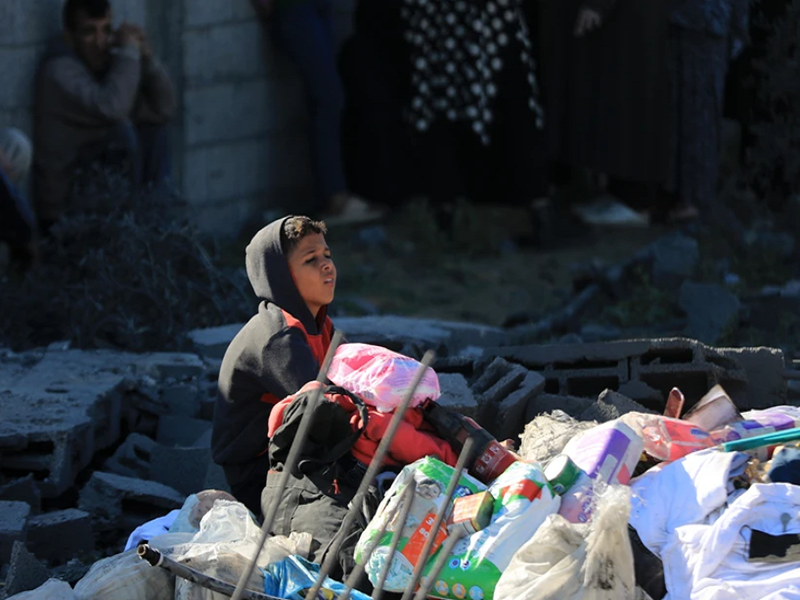 Một em nhỏ Palestine ngồi giữa đống đổ nát sau cuộc oanh kích của Israel xuống thành phố Rafah, Dải Gaza, ngày 7/1/2024. (Ảnh: THX/TTXVN)