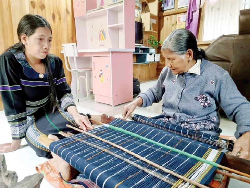 Nghệ nhân K’Glòng truyền dạy nghề dệt cho phụ nữ ở buôn làng