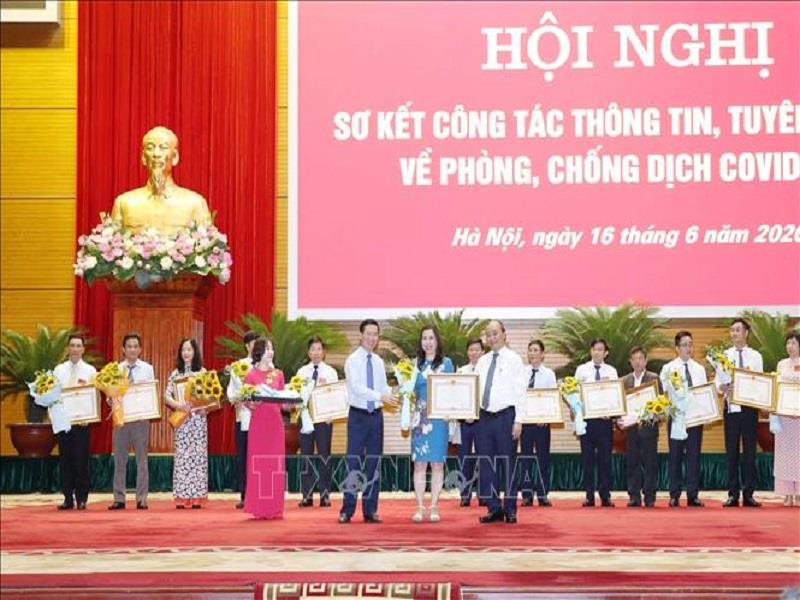 Thủ tướng Nguyễn Xuân Phúc và Trưởng Ban Tuyên giáo Trung ương Võ Văn Thưởng tặng Bằng khen của Thủ tướng cho các tập thể, cá nhân về thành tích trong thông tin, tuyên truyền phòng, chống COVID-19, ngày 16/6/2020. Ảnh: Thống Nhất - TTXVN