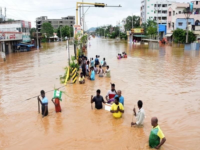 Người dân lội qua con phố bị ngập ở bang Andhra Pradesh, Ấn Độ, ngày 2/9. (Ảnh: Reuters)