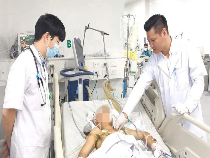 Thạc sĩ, bác sĩ Đồng Phú Khiêm, Phó Giám đốc Trung tâm Hồi sức tích cực, Bệnh viện Bệnh Nhiệt đới Trung ương (trái) thăm khám cho người bệnh.