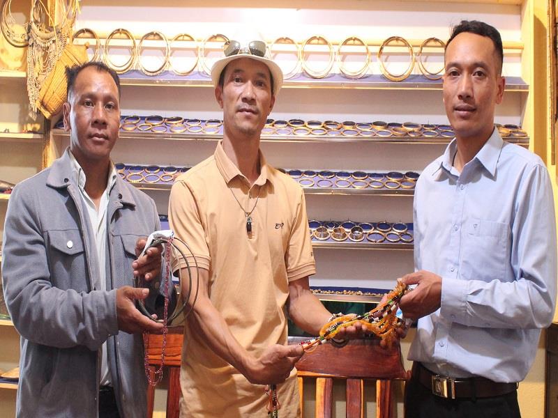 Phó Chủ tịch UBND xã Đạ Chais Kơ Să Ha Khrên (phải) tiếp nhận hiện vật do ông Nguyễn Quốc Dũng tặng