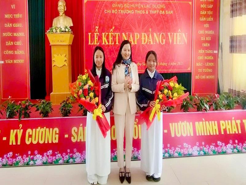 Đồng chí Trần Thị Chúc Quỳnh - Bí thư Huyện ủy Lạc Dương tặng hoa chúc mừng 2 học sinh của Trường THCS-THPT Đạ Sar vừa được kết nạp Đảng