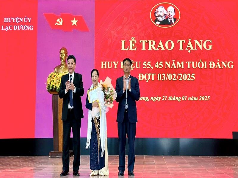 Đồng chí Ya Tiong - Phó Bí thư Thường trực Huyện ủy và đồng chí Bùi Thế - Chủ tịch UBND huyện trao Huy hiệu Đảng cho đảng viên 45 năm tuổi Đảng
