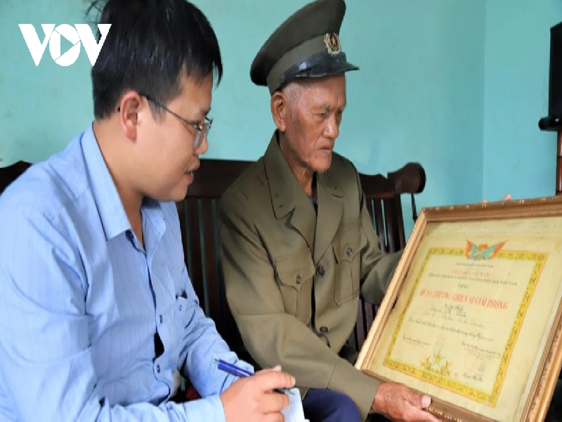 Cựu chiến binh K’Dĩnh, người K’ho, ở xã Lộc Nam, huyện Bảo Lâm cầm trên tay Huân chương Chiến sĩ giải phóng hạng Nhất kể về sự hy sinh gian khổ của thế hệ trước trong công cuộc đấu tranh giải phóng miền Nam, thống nhất đất nước