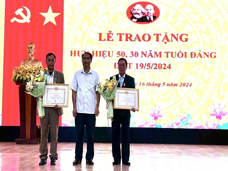 Phó Bí thư Thường trực Huyện ủy Lạc Dương Ya Tiong trao Huy hiệu Đảng cho các đảng viên 30 năm tuổi Đảng