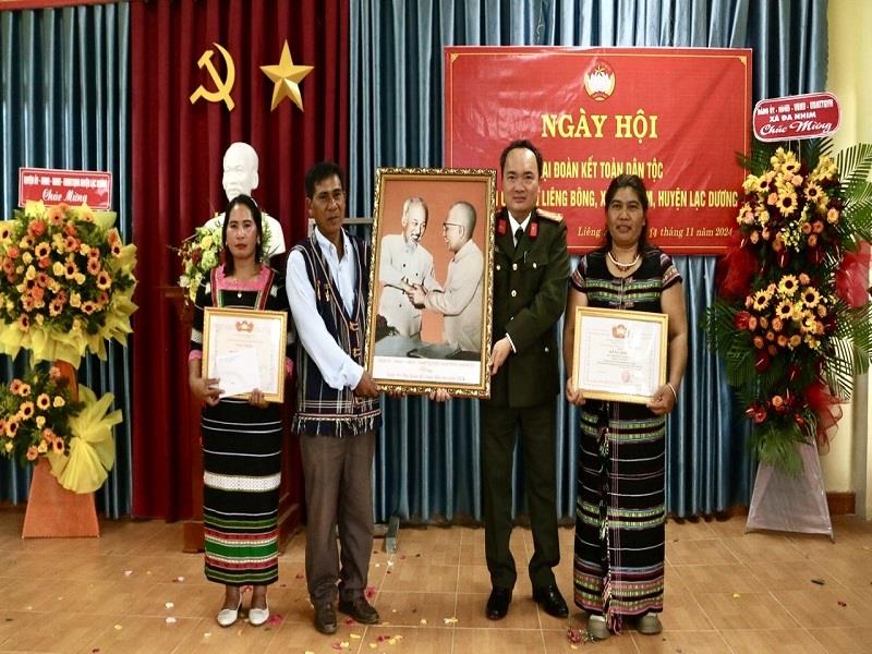 Đại tá Trương Minh Đương trao tặng cán bộ và Nhân dân thôn Liêng Bông bức ảnh “Bác Hồ và Bác Tôn”, trao Bằng công nhận danh hiệu Khu dân cư kiểu mẫu và phần quà trị giá 15 triệu đồng