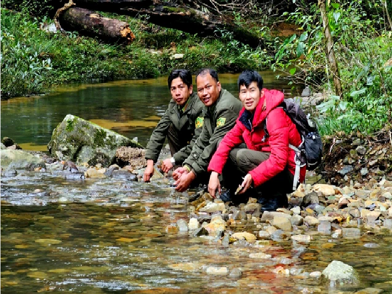 Anh Phạm Đờ Ni (góc trái) và anh Păng Tiang Min cùng cán bộ kiểm lâm rửa mặt bên con suối