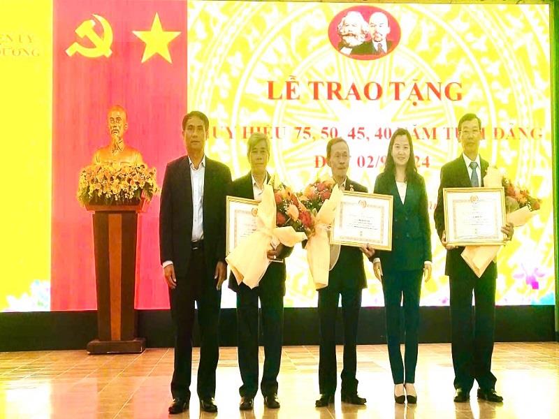 Đồng chí Trần Thị Chúc Quỳnh - Bí thư Huyện ủy Lạc Dương và đồng chí Ya Tiong - Phó Bí thư Thường trực Huyện ủy trao Huy hiệu 45 năm tuổi Đảng cho các đảng viên