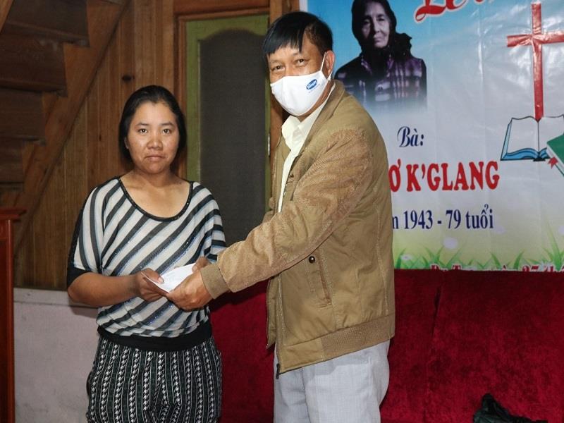 Đồng chí Dơ Woang Ya Gương - Phó Trưởng ban Dân tộc tỉnh trao phần quà hỗ trợ cho gia đình chị Kon Sơ K’SyLa