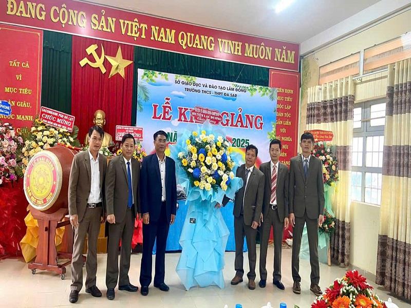 Đồng chí Ya Tong - Phó Bí thư Thường trực Huyện ủy tặng hoa chúc mừng khai giảng tại Trường THCS-THPT Đạ Sar