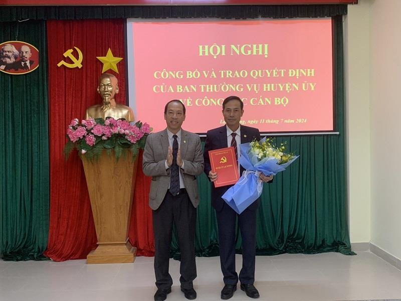 Đồng chí Sử Thanh Hoài - Bí thư Huyện ủy, Chủ tịch HĐND huyện trao Quyết định và tặng hoa chúc mừng đồng chí Bùi Văn Thụy