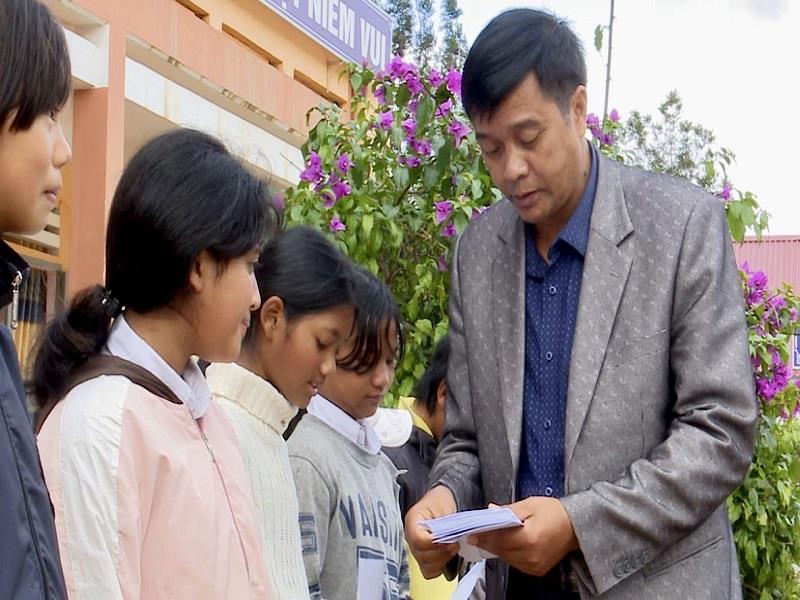 Ông Cil Poh - Phó Chủ tịch UBND huyện Lạc Dương trao học bổng cho các em học sinh. Ảnh: Anh Tuấn