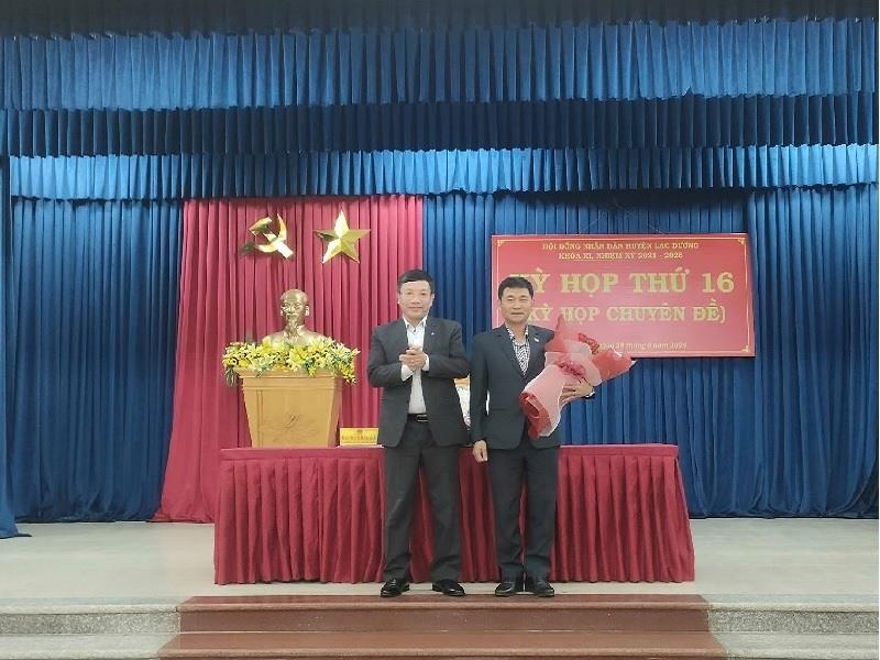 Đồng chí Bùi Thế - Phó Bí thư Huyện ủy, Chủ tịch UBND huyện tặng hoa chúc mừng đồng chí Hồ Quang Hùng-Chỉ huy trưởng Ban Chỉ huy Quân sự huyện