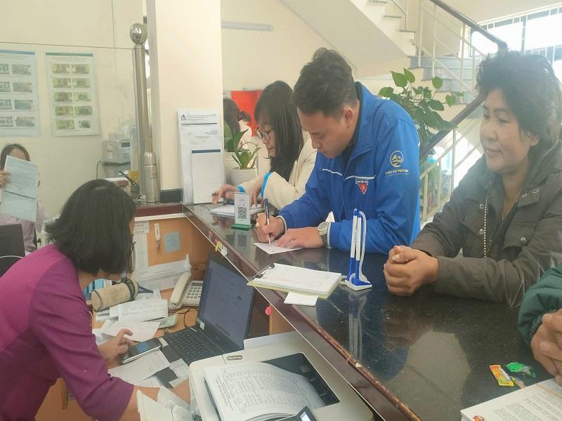 Các đoàn thể và một số người dân làm thủ tục gửi tiết kiệm tại Ngân hàng CSXH huyện