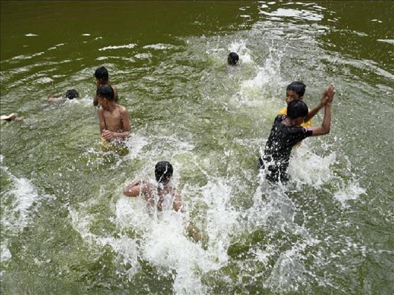 Trẻ em tắm ao tránh nắng tại  Dhaka, Bangladesh (Ảnh: AFP/TTXVN)