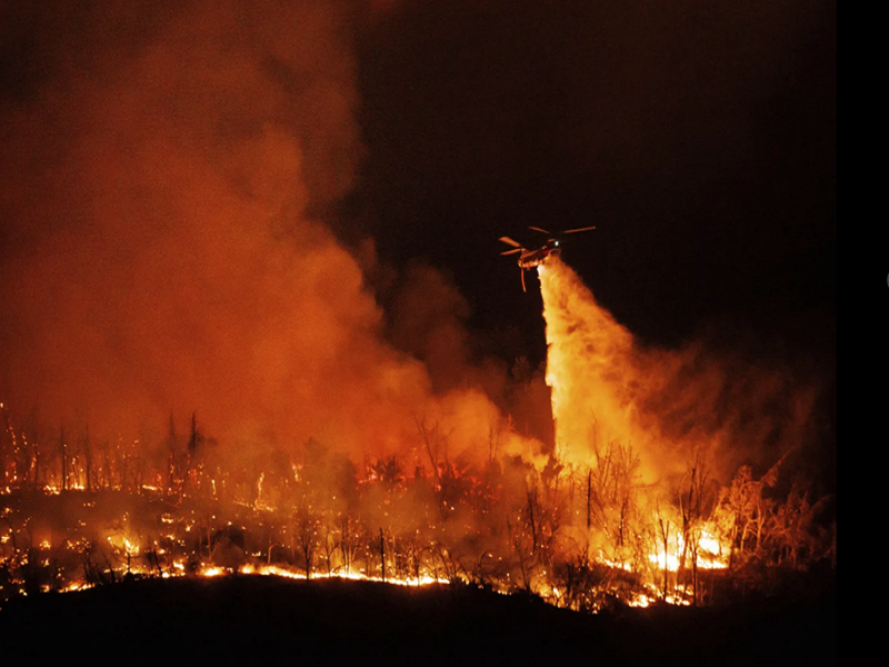 Trực thăng thả nước từ trên cao để dập tắt đám cháy rừng Thompson bùng phát hôm 2/7. (Ảnh: AP)