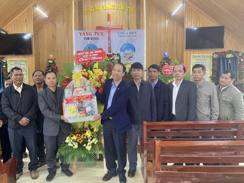 Đồng chí Sử Thanh Hoài - Phó Bí thư Huyện ủy, Chủ tịch UBND huyện tặng quà và lẵng hoa chúc mừng tại xã Đưng K’Nớ