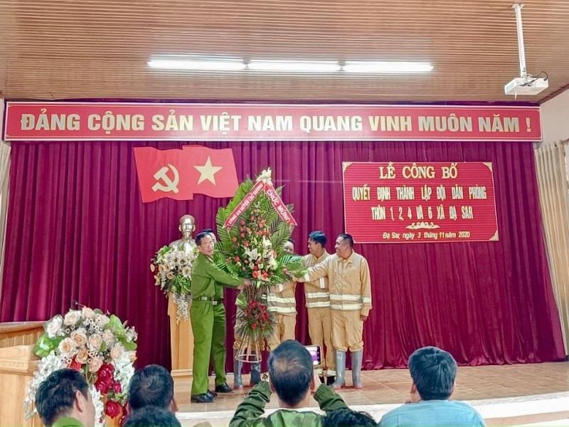 Đồng chí Phạm Phú Ty - Phó trưởng Công an huyện Lạc Dương tặng hoa chúc mừng tại lễ công bố quyết định