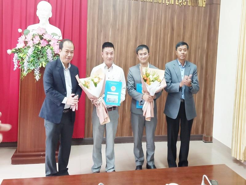 Các đồng chí Phó Chủ tịch UBND huyện Lê Chí Quang Minh và Cil Poh trao Quyết định của Chủ tịch UBND huyện và tặng hoa chúc mừng 02 đồng chí được bổ nhiệm lần này.