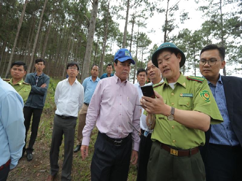 Lãnh đạo Hạt Kiểm lâm huyện Lạc Dương trao đổi với ông Phạm S các vị trí đất rừng bị lấn chiếm qua bản đồ trên điện thoại