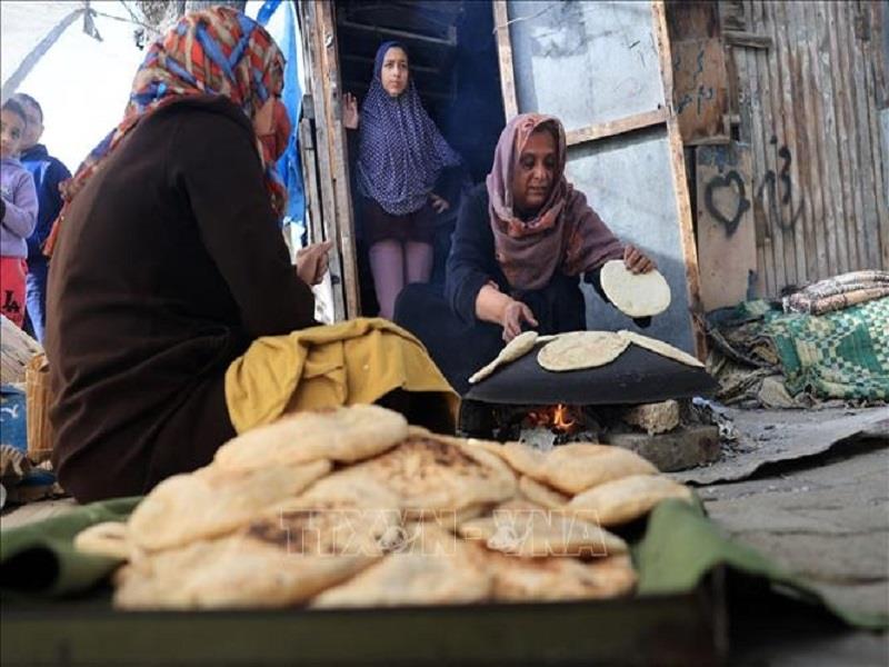 Người dân nướng bánh ở khu lều tạm ở Rafah, phía Nam Dải Gaza ngày 25/11, sau khi có lệnh ngừng bắn. (Ảnh: AFP/TTXVN)