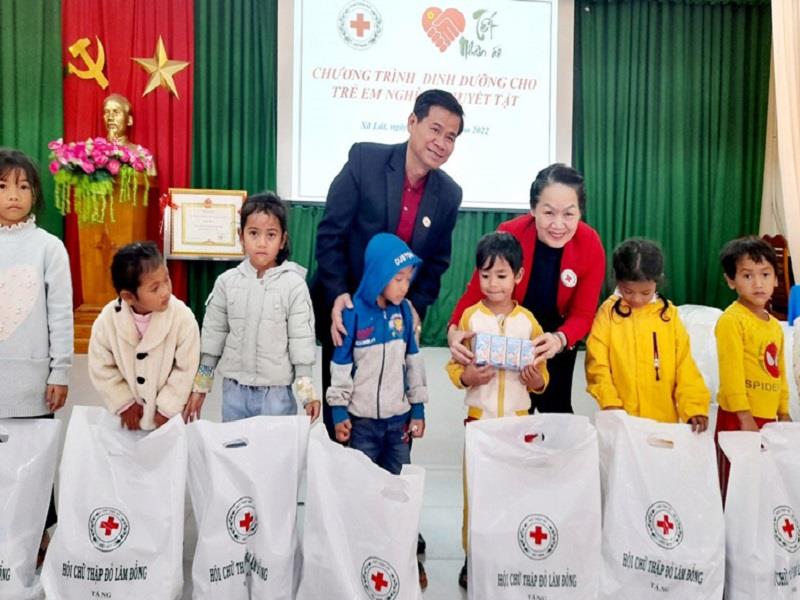Bà Bùi Thị Hòa - Chủ tịch Hội Chữ thập đỏ Việt Nam cùng ông Nguyễn Quang Minh - Chủ tịch Hội CTĐ Lâm Đồng trao tặng sữa dinh dưỡng cho trẻ em xã Lát