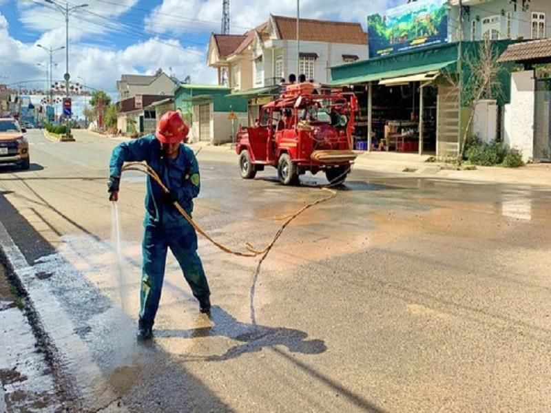 Thành viên Đội PCCC và CHCN tự quản thị trấn Lạc Dương xịt rửa đường ở những khu vực vừa xảy ra sạt lở, bùn đất tràn xuống đường giao thông