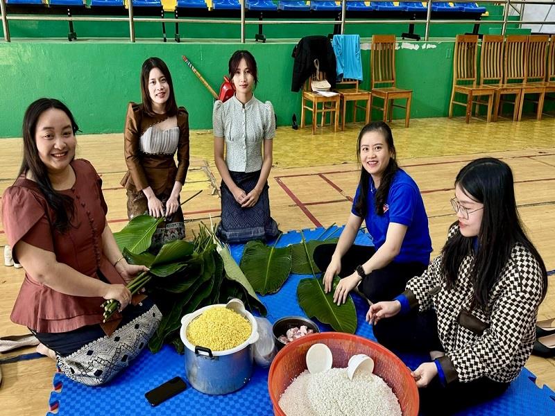Đoàn viên, thanh niên huyện Lạc Dương hướng dẫn sinh viên Lào gói bánh chưng