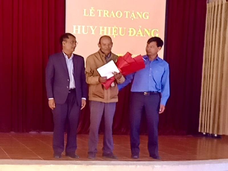 Đồng chí Ya Tiong - Phó Bí thư Thường trực Huyện ủy, Chủ tịch HĐND huyện (thứ nhất trái ảnh) trao Huy hiệu 30 năm tuổi Đảng