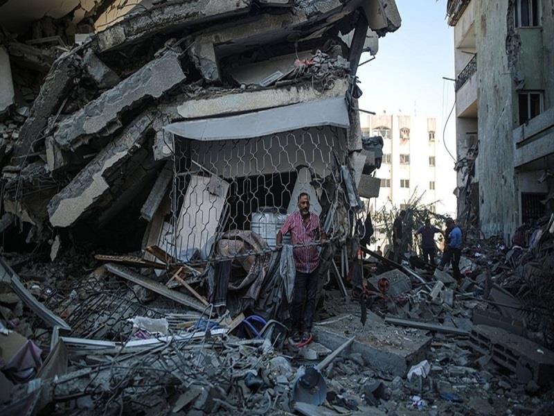 Một cư dân ở thành phố Gaza đứng giữa đống đổ nát của những tòa nhà đã bị phá hủy ở khu phố al-Zahra. (Ảnh: Anadolu Agency)